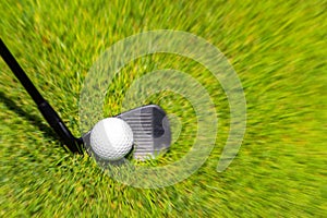 Closeup of hitting golf ball with golf iron club golf course wih motion blur effect