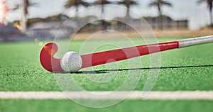 Closeup, hockey and hockey stick with ball on field in sunshine for sport, contest or competition in summer. Sports