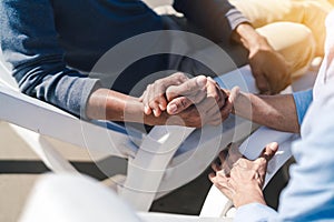 Closeup holding hands of couple senior elder retirement resting