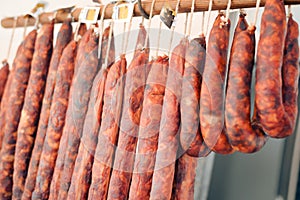 Closeup on home made meat salami sausage at market hanging in raw