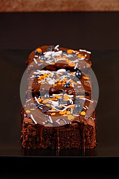 Closeup homemade brownie on a dark plate.