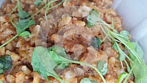 Closeup of homemade traditional Italian Risotto on with shrimp, squids and herbs with fresh Parmesan cheese served on a plate.