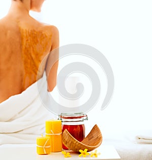 Closeup on honey spa therapy ingredients and relaxed woman