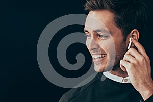 Closeup horizontal portrait of young handsome man smiling and have a call with a colleague isolated on black background