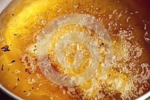 Closeup of hot bubbling boiling oil in a deep fryer.