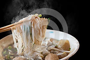 Closeup of hot noodles with smokes on black background
