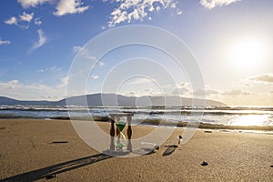 Closeup of hourglass on the sand.Timer Beach Sunset