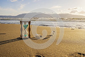 Closeup of hourglass on the sand.Timer Beach Sunset