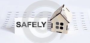 Closeup of house wooden model with blank for text SAFELY on chart background