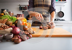 Closeup on housewife cutting purple tomato