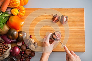 Closeup on housewife cutting purple tomato