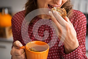 Closeup on housewife drinking tea with bread