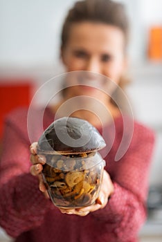 Closeup on housewife showing jar of mushrooms