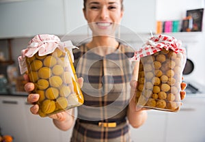 Closeup on housewife showing jars with compote