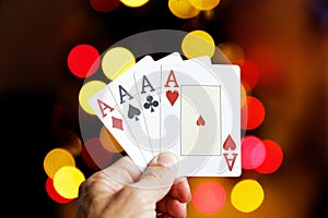 Closeup human hand holding four playing cards aces