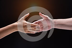 Closeup human hand ,between mand and woman.they are reaching to touch together,the sign and symbol of friendship