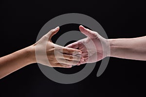 Closeup human hand ,between mand and woman.they are reaching to touch together,the sign and symbol of friendship