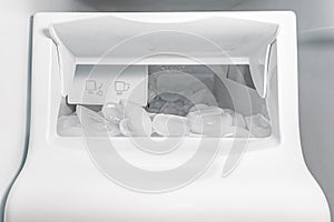 Closeup of ice maker, ice machine in refrigerator with ice cubes