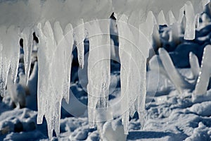 Closeup of icicles covering security fence on a sunny winter