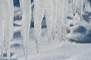 Closeup of icicles covering security fence on a sunny winter