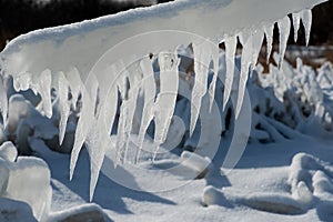 Closeup of icicles covering security fence on a sunny winter