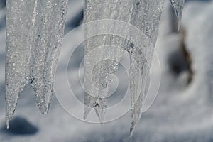 Closeup of icicles covering security fence on a sunny winter