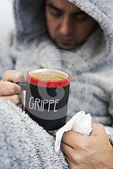 Ill man and mug with word grippe, flu in French