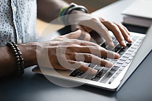 Closeup image african male hands typing on laptop keyboard