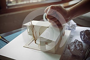 Closeup image of an angry architects try to destroy an architecture model on the table