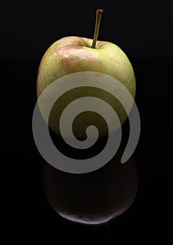 Closeup image of apple on black background with reflection