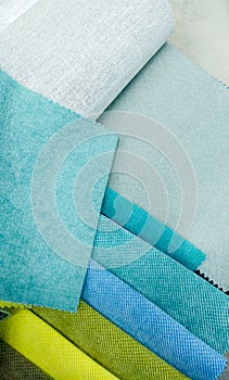 Closeup image of assortment of fabric samples for soft furniture. Blue and green pieces of material. Abstract closeup