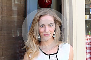 Closeup image of the beautiful blond girl exiting a shop