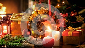 Closeup image of burning candles in traditional wreath against Christmas tree and fireplace