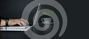 Closeup image of businessman working and typing on laptop keyboard in office photo
