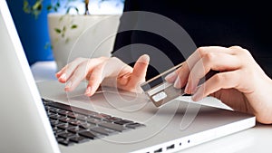 Closeup image of businesswoman using credit card to pay online