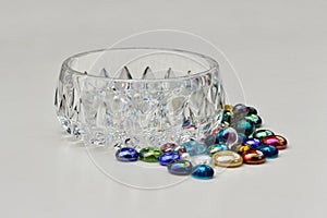 Closeup image of colorful dragon tears glass stones surrounding a small crystal bowl