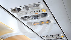 Closeup image of emergency signs on the ceiling of passenger airplane