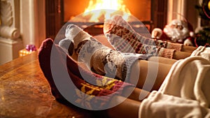 Closeup image of family wearing woolen socks warming by the fireplace