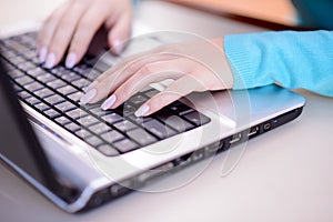 Closeup image of female hands typing on laptop