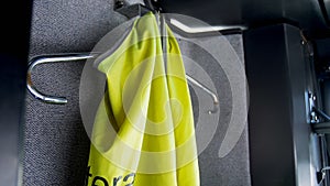 Closeup image of green safety vest hanging on hanger at passenger bus