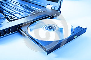 Closeup image of a laptop and a CD / DVD disc