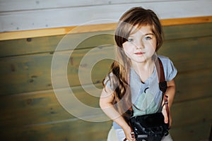 Closeup image of a little girl with photocamera.