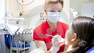 Closeup image of little girl visiting pediatric dentist in clinic