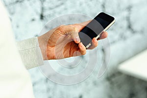 Closeup image of a male hand holding smartphone