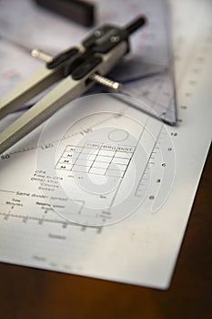 Closeup image of a navigator\'s radar plotting chart with a triangle and compass divider