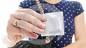 Closeup image of pack of condom in female hand. Concept of contraception and safety in sex