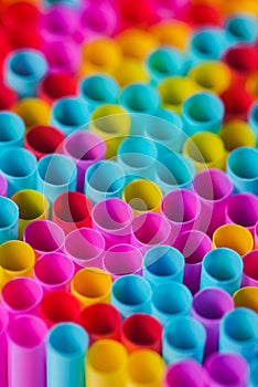 Closeup image of pastel colored straws on black background