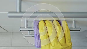 Closeup Image with Person Hands Wearing Protective Yellow Household Gloves Cleaning the Kitchen Furniture