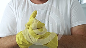 Closeup Image with a Person Hands Wearing Protective Yellow Household Gloves Used in the Kitchen Cleanse