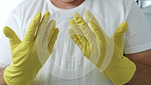 Closeup Image with a Person Hands Wearing Protective Yellow Household Gloves Used in the Kitchen Cleanse